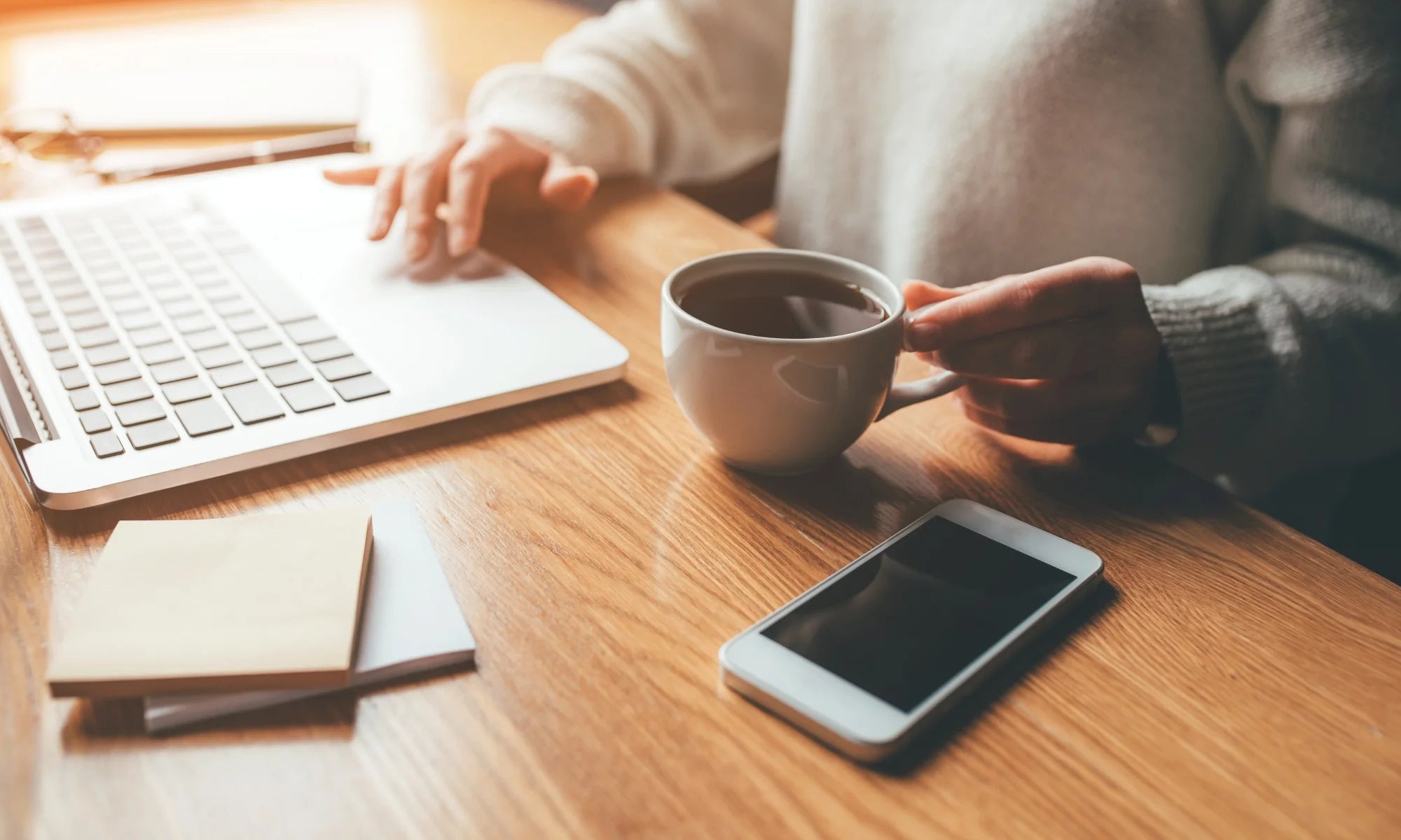 hands ond desk with coffe and laptop